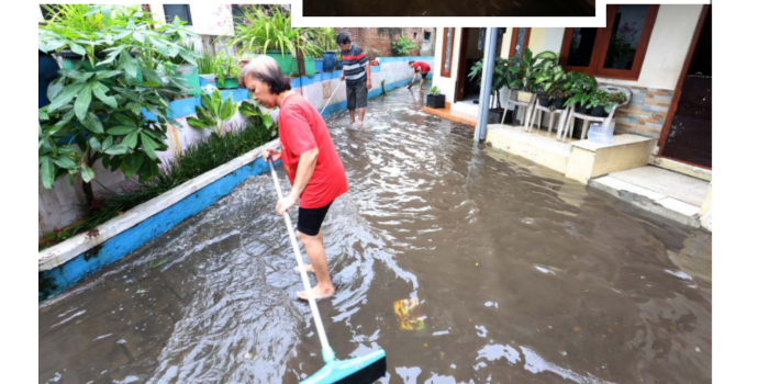 LANGGANAN: Mukini tak bisa berbuat banyak saat rumahnya tergenang air kemarin (7/3). Warga melakukan kerja bakti mengalirkan genangan ke saluran air setelah hujan reda. (DARMONO RADAR MALANG)