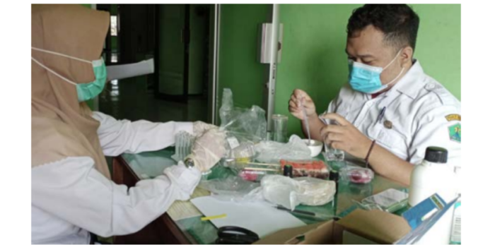 PENGECEKAN: Tim sanitarian dari Puskesmas Dinoyo memeriksa sampel takjil dari pedagang untuk mengetahui kandungan bakteri, formalin, boraks, dan pewarna berbahaya. (PUSKESMAS DINOYO FOR RADAR MALANG)