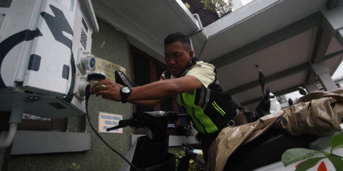 SIAP SAMBUT MUDIK: Petugas keamanan mengecek fungsi SPKLU di Kantor PLN UP3 Malang, kemarin (SATRIA CAHYONO / RADAR MALANG).