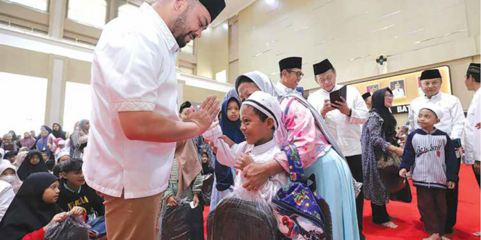 GEMBIRA: Wakil Wali Kota Batu Heli Suyanto memberikan santunan kepada salah seorang anak yatim dalam acara penyaluran bantuan ZIS di Graha Pancasila Balai Kota Among Tani Batu beberapa waktu lalu.