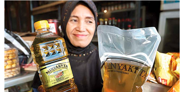 TIDAK ADA KELUHAN: Salah seorang pedagang pasar Kebalen menunjukkan bahwa Minyakita yang dia jual memiliki volume 1 liter tiap kemasan.