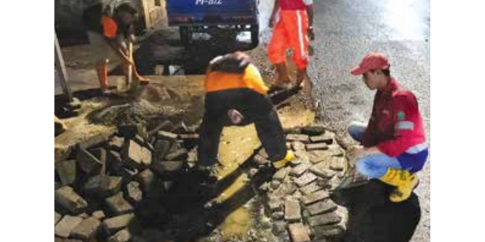SWADAYA: Warga yang tergabung dalam Kelurahan Tangguh Bakalankrajan memperbaiki Jalan Pelabuhan Tanjung Emas (Kelurahan Bakalankrajan for Radar Malang).