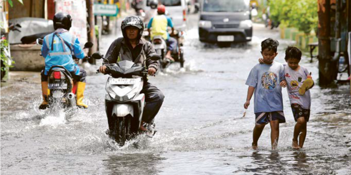 SUDAH EMPAT HARI: Pengendara melintas di Jalan Joyoboyo, Desa Medaeng, Kecamatan Waru, yang tergenang.