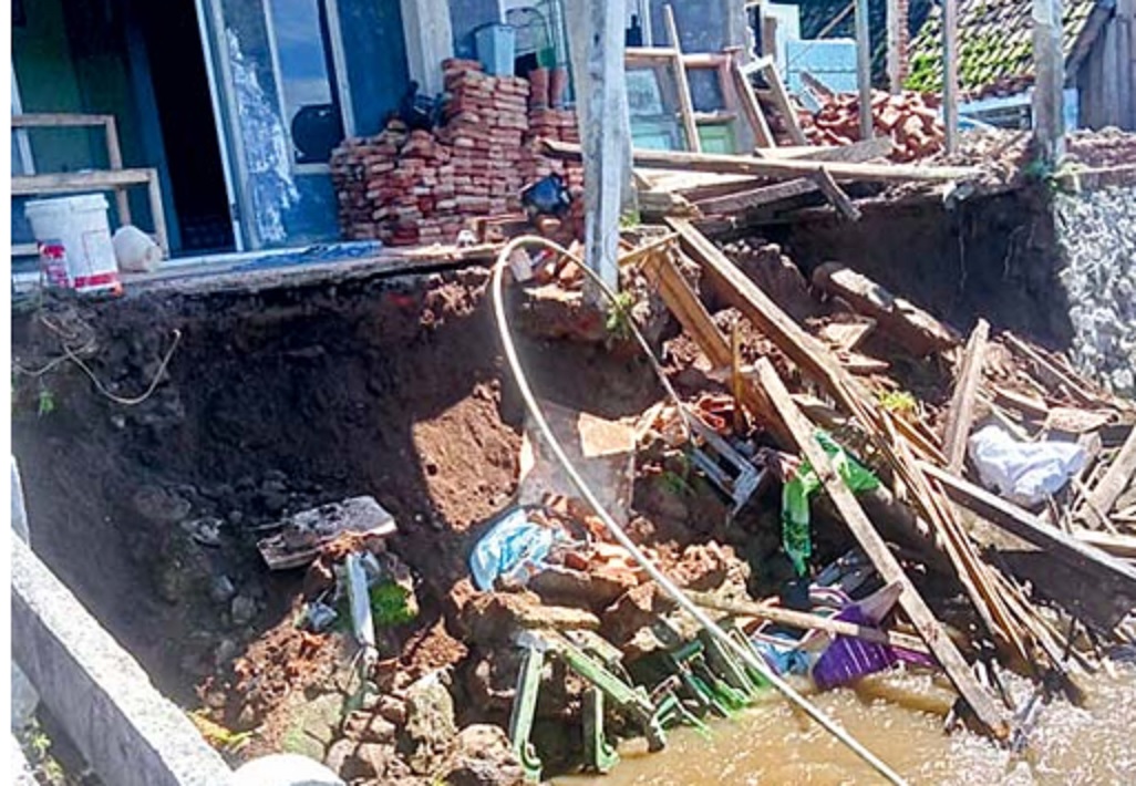TERKIKIS: Material yang berasal dari tembok penahan tanah dan teras rumah Mulyadi jatuh ke sungai di Dusun Sukoanyar, Desa Mulyorejo, Kecamatan Ngantang (11/3).