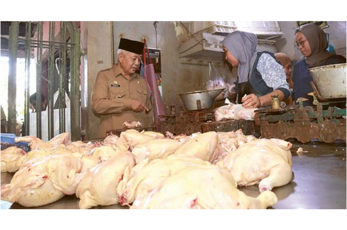 KENDALIKAN HARGA: Bupati Malang H M. Sanusi menanyakan harga ayam ke salah satu pedagang di Pasar Kepanjen. (PROKOPIM FOR RADAR MALANG)