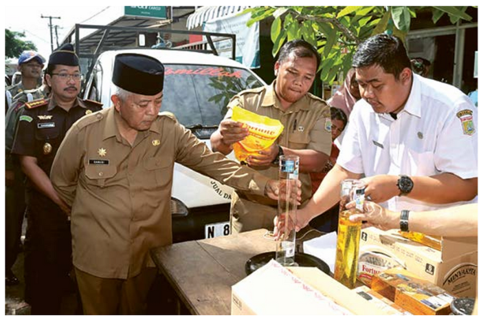DEMI MASYARAKAT: Bupati Malang H M. Sanusi (kiri) menakar volume minyak goreng kemasan di PT Subur Mitra Sukses kemarin. (PROKOPIM FOR RADAR MALANG)