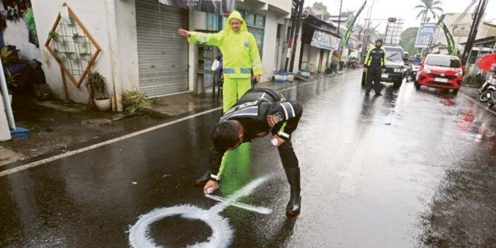 Polisi memberi tanda lokasi kecelakaan yang menewaskan seorang pelajar SMA di Jalan Galunggung, Kelurahan Gading Kasri, Kecamatan Klojen, kemarin (13/3) (DARMONO/RADAR MALANG).
