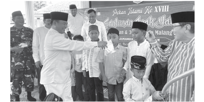 SANTUNAN: Anggota DPRD Kabupaten Malang rahmat Kartala menyerahkan hadiah kepada anak yatim di Ampelgading kemarin (16/3). (MARDI SAMPURNO/RADAR KANJURUHAN)