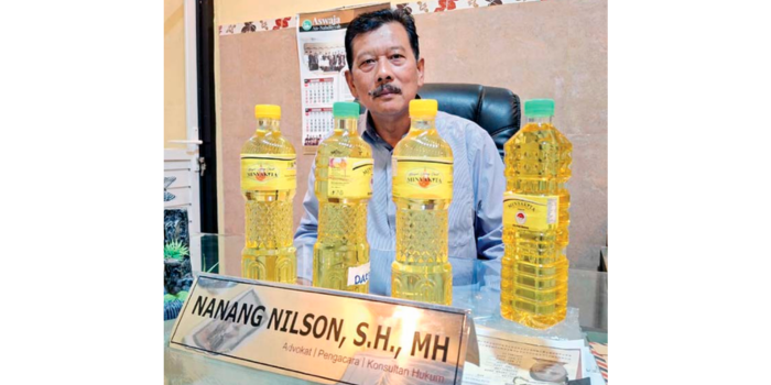 DUKUNG PENGUSUTAN: presiden LPKNI Nanang Nilson menunjukkan bahwa kemasan produk Minyakita mereka berbeda dengan yang diperiksa pemkot Malang dan kepolisian di pasar Bunulrejo pada 13 Maret lalu.