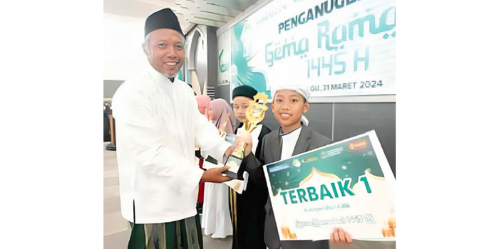 APRESIASI: General Manager Radar Malang M. Athoullah (kiri) mem berikan hadiah kepada salah satu jawara Gema Ramadan 1445 H tahun lalu.