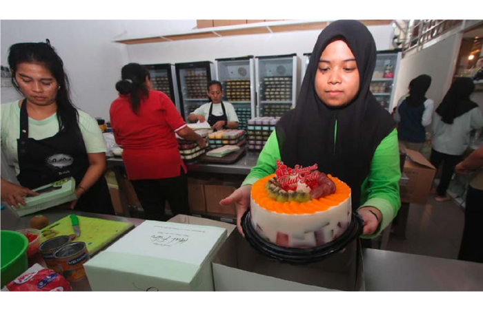 TAMBAH PETUGAS: Salah satu karyawan Mumu Puding menunjukkan tart puding yang dipesan pelanggan, kemarin. (SATRIA CAHYONO / RADAR MALANG)