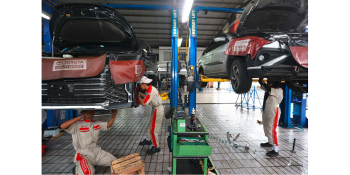 PERSIAPAN MUDIK: Dua mobil tengah diservis di Bengkel Toyota Kartika Sari Malang. Jumlah kendaraan yang meman faatkan layanan di sana mulai meningkat pada pekan ini. (DARMONO/RADAR MALANG)