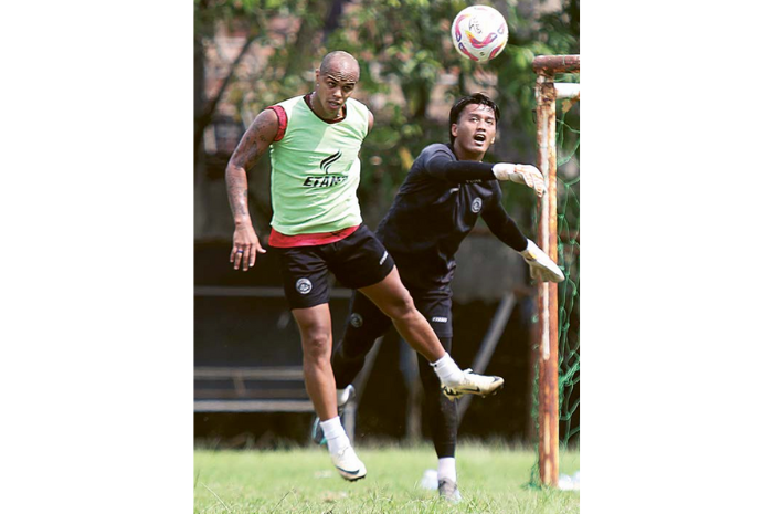 PANASI MESIN: Wiliam Marcilio (kiri) berebut bola dengan kiper Arema FC Dicky Agung Setiawan dalam sesi latihan di Lapangan Universitas Brawijaya, bulan Februari lalu. (SATRIA CAHYONO/RADAR MALANG)