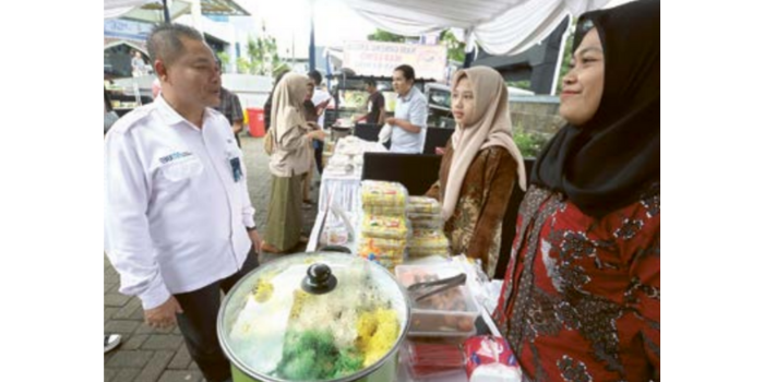 Deputi Branch Manager Business BTN KC Malang Budi Siswaya mengunjungi salah satu UMKM di Bale Festival kemarin (DARMONO/RADAR MALANG).