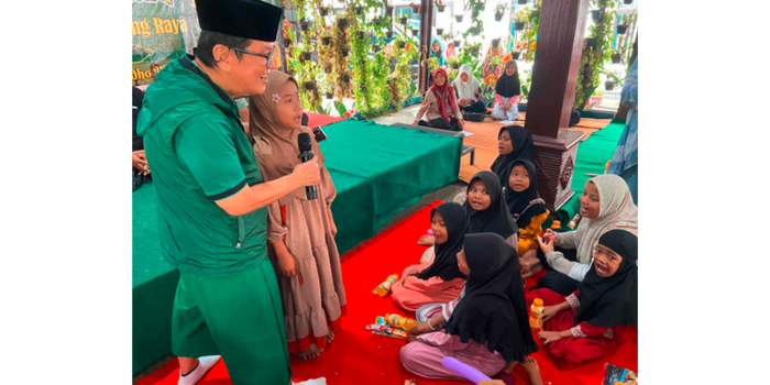 LAGU KEBANGSAAN: Iwan Kurniawan meminta Ifa, salah satu anak yatim, untuk memandu teman-temannya menyanyikan lagu Indonesia Raya, di Pendopo Kecamatan Kasembon, kemarin (22/3).