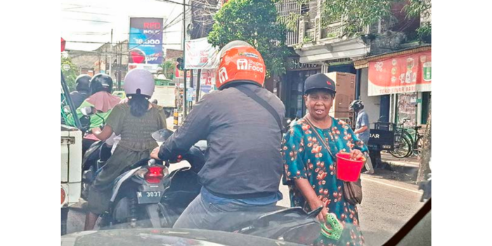 SEGERA DITERTIBKAN: Seorang perempuan parobaya mengamen di simpang empat Jalan A. Yani, Kecamatan Kepanjen kemarin (22/3).