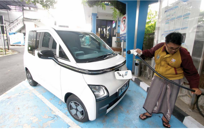FAST CHARGING: Pengendara mengisi ulang daya baterai mobil listrik di SPKLU PLN UP3 Malang. Ada empat SPKLU buka 24 jam selama mudik Lebaran. (SATRIA CAHYONO/RADAR MALANG)