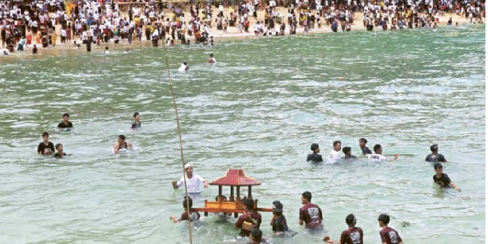 RANGKAIAN MELASTI: Setelah memanjatkan doa bersama di pinggir Pantai Balekambang, umat Hindu melarung sesaji ke laut. Foto kiri, sesaji yang dilarung umumnya berisi hasilhasil bumi.