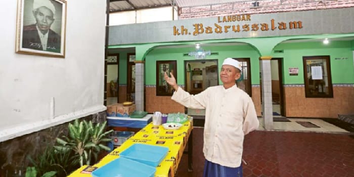 TERUSKAN DAKWAH: Salah satu pengurus Langgar KH Badrussalam menunjukkan foto tokoh yang berjasa melakukan dakwah di sana