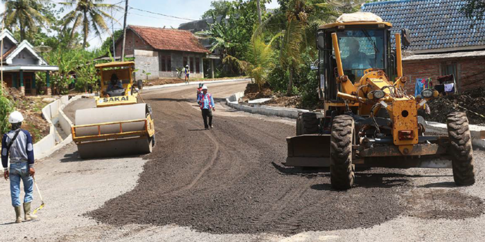 DIKEBUT: Motor grader dan tandem roller digunakan untuk memadatkan lapisan agregat di Jalan Srigonco sebelum proses pengaspalan kemarin (25/3).