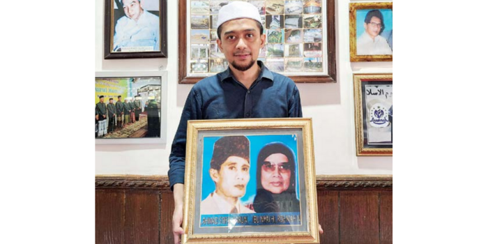 GENERASI KETIGA: Ahmad Syifaurrahman menunjukkan foto KH Muhammad Syifa&rsquo; dan Nyai Rohmah Noor Syifa&rsquo;, kakek dan neneknya di Ponpes Nurul Ulum, Senin lalu (24/3) (Nabila Amelia/ Radar Malang).