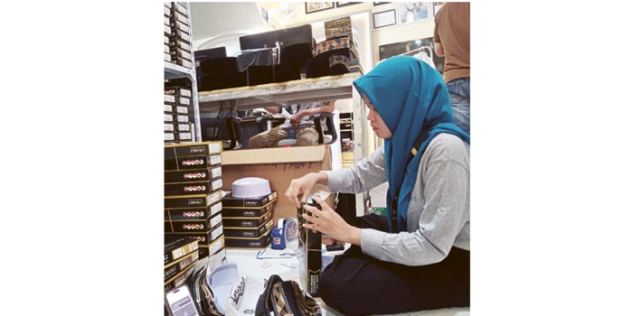 LEMBUR: Karyawan salah satu toko busana mengemas peci yang dipesan pelanggan kemarin. (DOKUMEN JAWA POS)