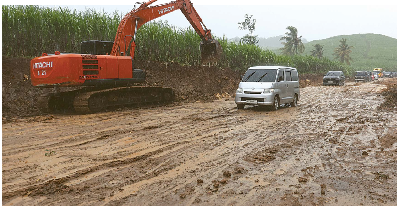 PROSES PERBAIKAN: Beberapa kendaraan wisatawan melintasi jalur Gondanglegi Balekambang. Sebagian berlumpur material pengerjaan jalan diguyur hujan. (DARMONO/RADAR MALANG)