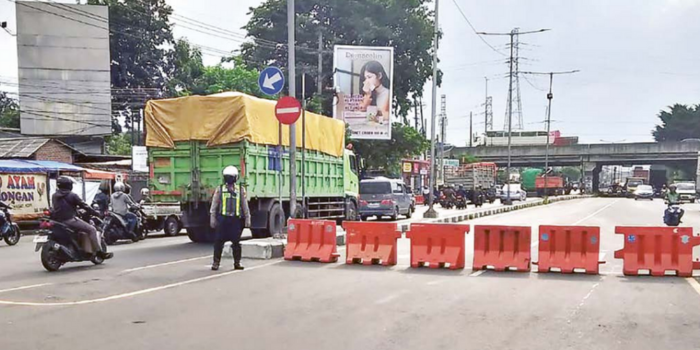 KONDISIONAL: Petugas menahan kendaraan dari Krian yang menuju Jalan Letjen Sutoyo, Waru, dengan memasang water barrier di traffic light Medaeng (SATLANTAS POLRESTA SIDOARJO).