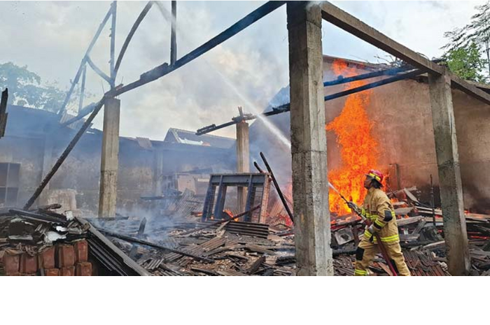 GERAK CEPAT: Tim dari Damkar Kabupaten Malang menyemprotkan air di konstruksi bangunan yang terbakar di Desa Krebet, Kecamatan Bululawang. (DAMKAR KABUPATEN MALANG FOR RADAR KANJURUHAN)