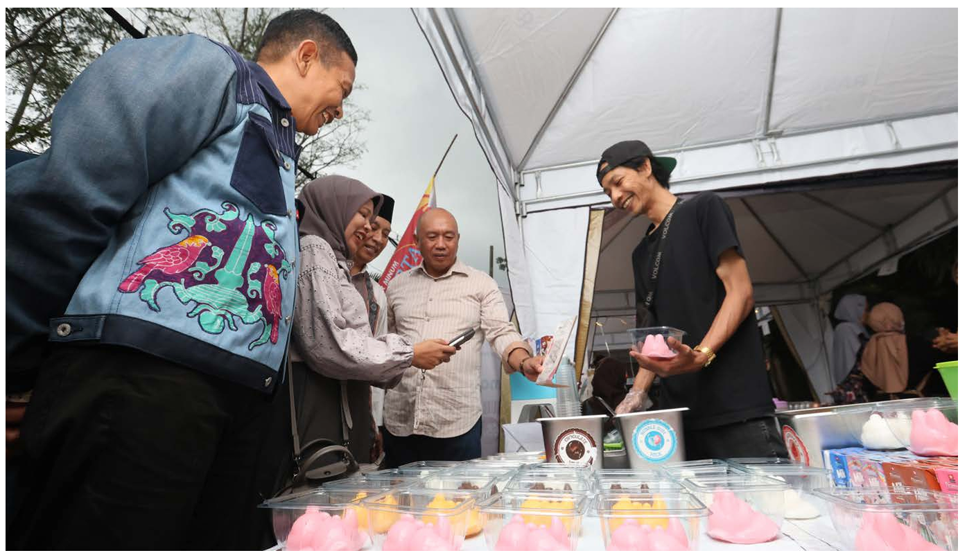 Wali Kota Malang Wahyu Hidayat (kiri) mengunjungi stan penjual puding setelah membuka event Madyopuro Mangano: Budaya Wisata Kuliner Halal Cashless di Terminal Madyopuro. (DARMONO/ RADAR MALANG)