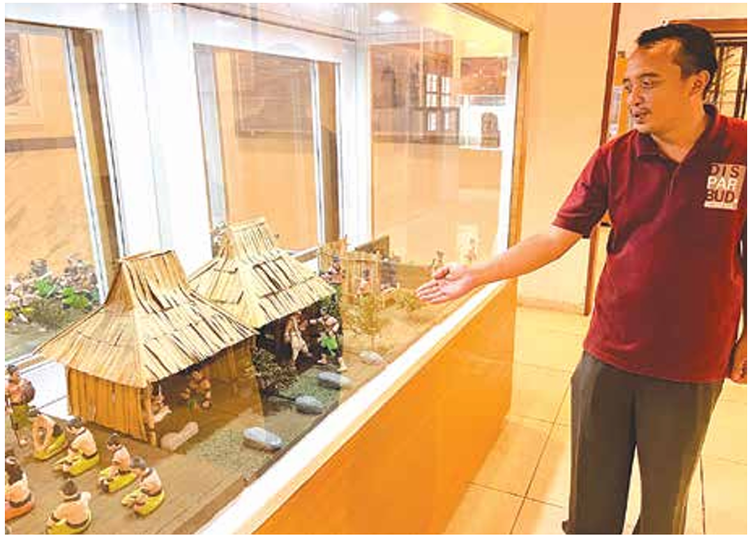 GAET PENGUNJUNG: Salah satu pemandu pengunjung di Museum Singhasari menunjukkan koleksi yang bakal ditata ulang. (NAHDIATUL AffANDIAH/RADAR KANJURUHAN)