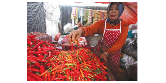 PERMINTAAN TINGGI: Pedagang sayur di pasar Kebalen mengaku jumlah pembeli cabai tetap banyak meskipun harganya kembali naik kemarin (6/4). (SATRIA CAHYONO/RADAR MALANG)