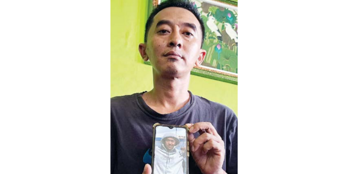 TINGGAL KENANGAN: Nanang Kuswanto menunjukkan foto Alfin Syafiq Ananta yang masih tersimpan di ponselnya (BIYAN MUDZAKY HANINDITO/RADAR MALANG).