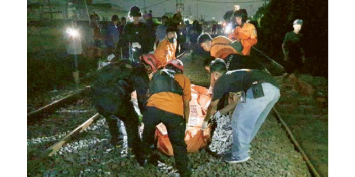 NYAWA MELAYANG: Petugas mengevakuasi korban yang tertabrak kereta di perlintasan sebidang Kalibokor dan terseret hingga 100 meter. (Dokumentasi BPBD Surabaya for Jawa Pos)