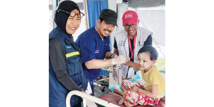 UTAMAKAN KEMANFAATAN: Dr. Aulia Dewi Kusumawati SpEM (kiri) ikut menolong salah satu anak di Myanmar, beberapa hari lalu (Aulia Dewi Kusumawati For Radar Malang).