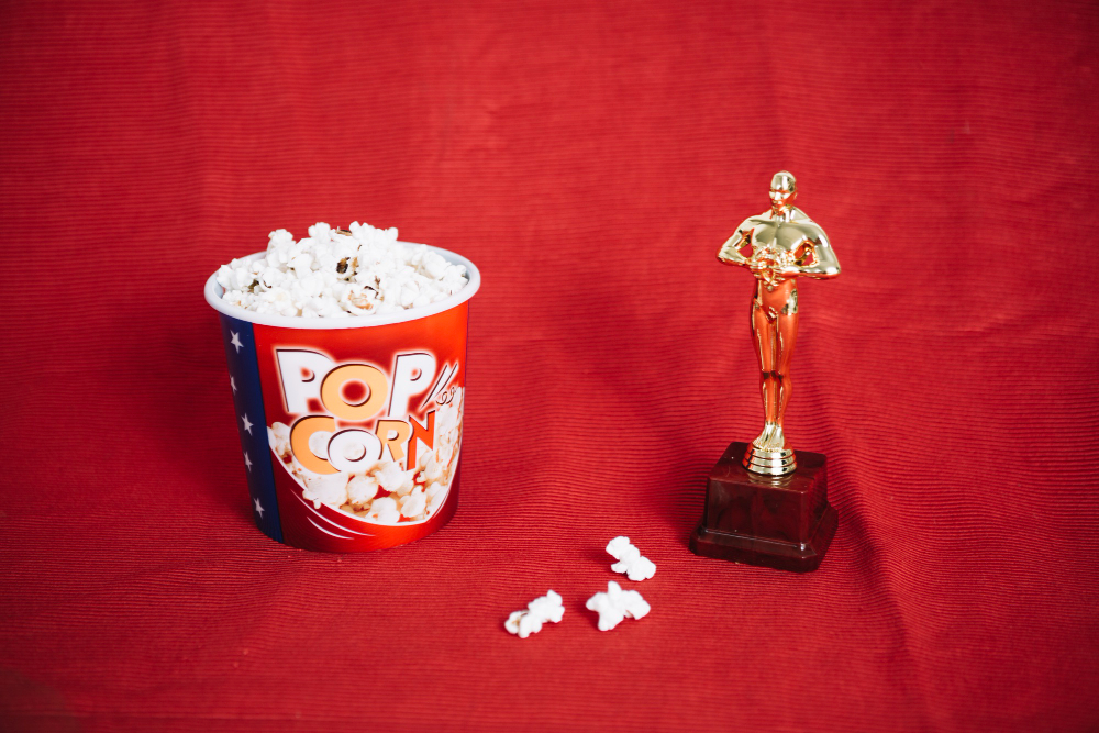 Berondong jagung dan Piala Oscar di atas kain merah. (Freepik)