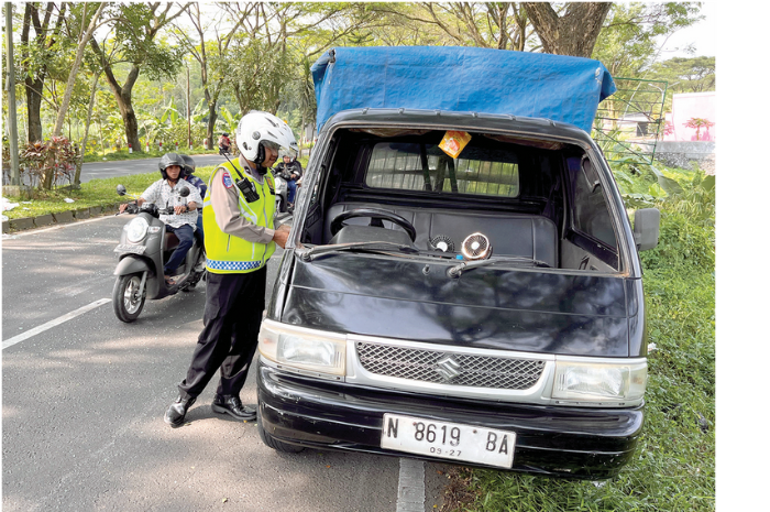 LAKA: Anggota Satlantas Polres Malang memeriksa kondisi pikap terguling di Jalibar yang sudah dikembalikan ke posisi semula kemarin (15/4). (NAHDIATUL AFFANDIAH/RADAR KANJURUHAN)