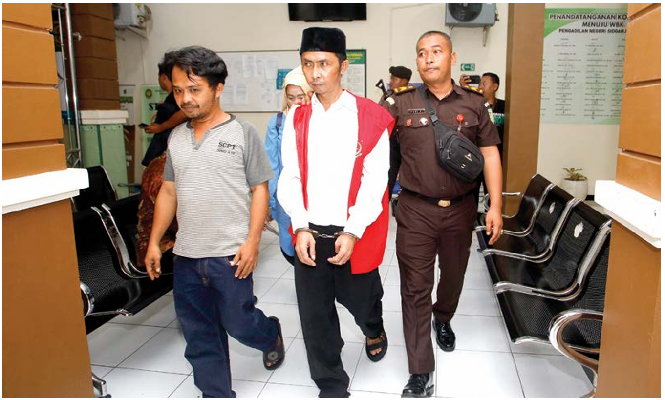 Terdakwa Muhammad Ihyak (tengah) menuju ruang sidang Pengadilan Negeri Sidoarjo untuk menjalani sidang kasus kepemilikan 30 kilogram sabu-sabu pada Selasa (15/4) petang. (ANGGER BONDAN/JAWA POS)