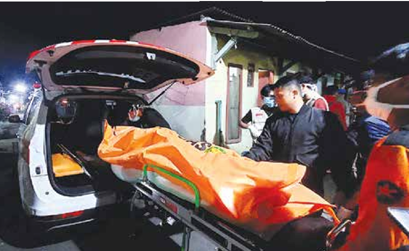 DIBAWA KE PUSKESMAS: Personel dari Polsek Pakis bersama tenaga kesehatan (nakes) mengevakuasi jenazah korban, Kamis malam (17/4). (POLSEK PAKIS FOR RADAR KANJURUHAN)
