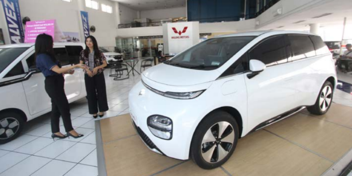 Salah satu warga menanyakan spesifikasi mobil listrik dari Wuling, kemarin (18/4). Tren penjualan pada awal tahun cenderung menurun (SATRIA CAHYONO / RADAR MALANG).