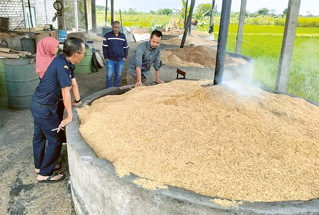Shubkhi Basyar (kanan) pengelola industri sekam padi berada di area pabriknya. Bersama sejumlah pelaku usaha lain, ia sudah mulai terimbas efek Tarif Trump. (GALIH WICAKSONO/JAWA POS)