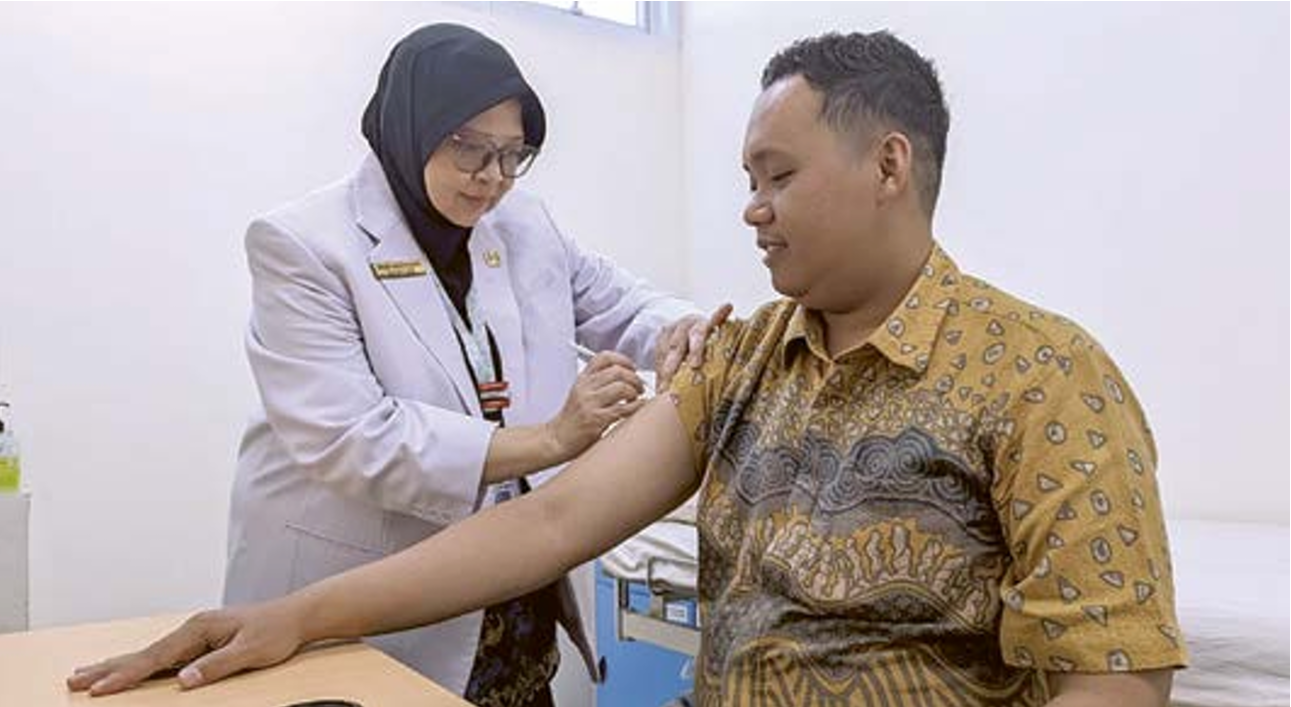 PROTEKSI KESEHATAN: Dokter Dewi Andojowati dari RS Menur memberikan vaksin meningitis kepada calon jamaah haji (CJH) kemarin. (RAMADHONI CAHYA/JAWA POS)