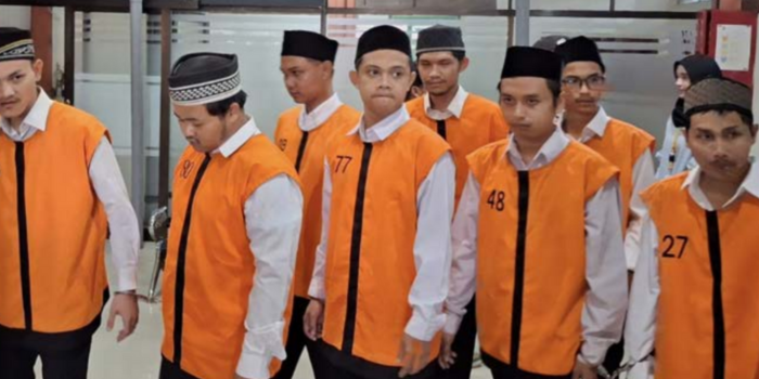 MENUNGGU PUTUSAN: Delapan terdakwa kasus pabrik narkotika berjalan keluar ruang sidang Pengadlan Negeri Malang setelah membacakan pleidoi atau pembelaan kemarin (21/4).