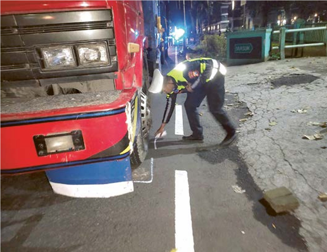 TEWASKAN SATU ORANG: Polisi melakukan olah TKP kecelakaan yang melibatkan pemotor dengan truk di Jalan Panji, Kepanjen, Rabu (23/4). (SATLANTAS POLRES MALANG FOR RADAR MALANG)