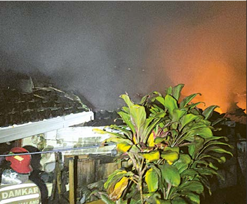 RUGI RATUSAN JUTA: Personel UPT Pemadam Kebakaran Kota Malang berusaha memadamkan api yang membakar rumah di Jalan Letjen Sutoyo Gang IV, Kamis malam (24/4). (UPT DAMKAR KOTA MALANG / RADAR MALANG)