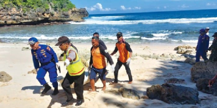 POSISI BERGESER: Polisi dan relawan mengevakuasi jenazah Sahnan yang tenggelam di perairan Pantai Kondangmerak, Desa Sumberbening, Kecamatan Bantur, kemarin (26/4).