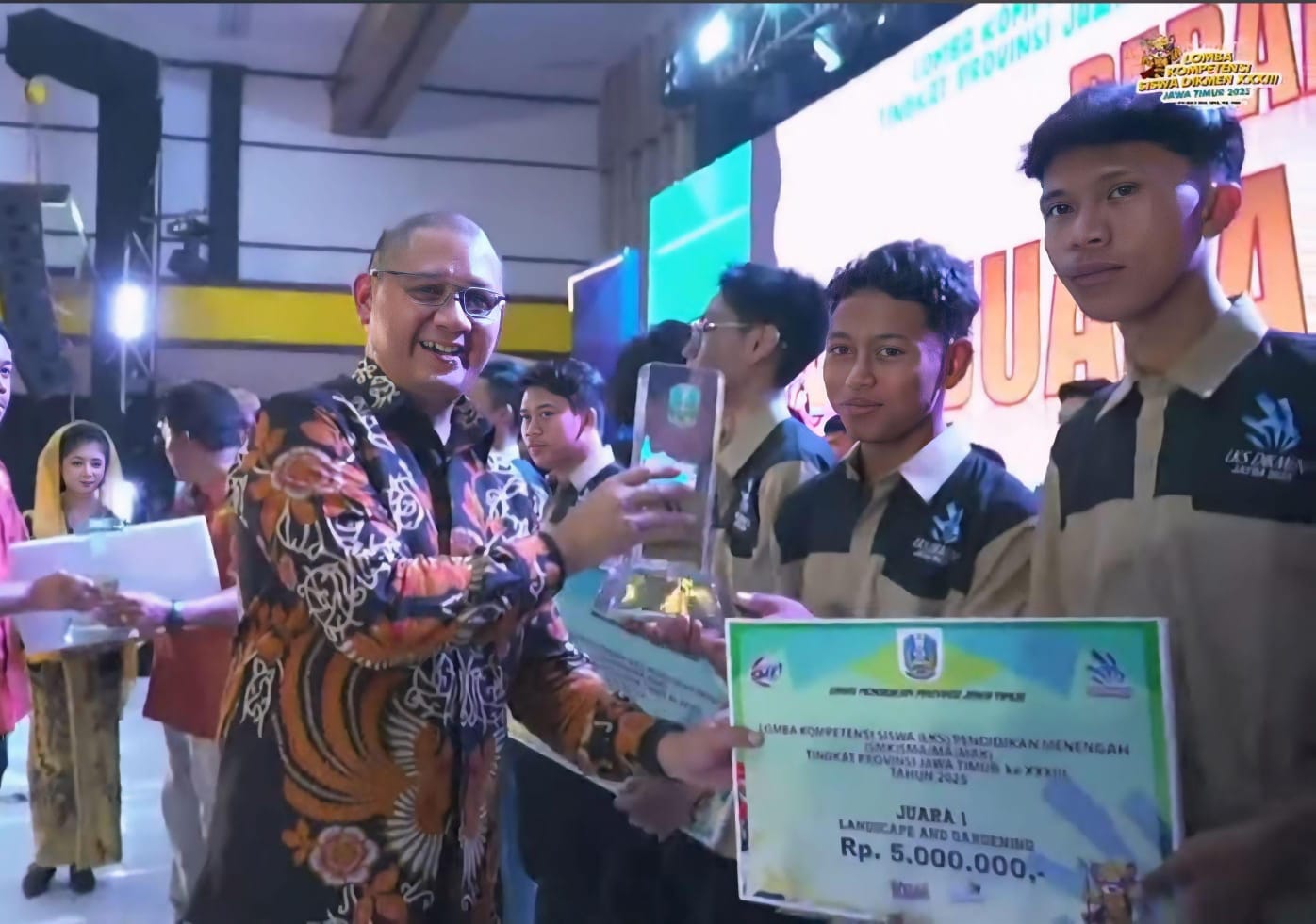 BACK TO BACK : Kepala Dinas Pendidikan Provinsi Jatim DR Aries Agung Paewai SSTP MMe (kiri) menyerahkan hadiah Juara 1 LKS Jatim pada siswa SMK NU Sunan Ampel Poncokusumo, Jumat (25/4).