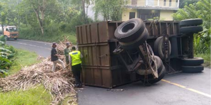 MENUTUP JALAN: Gandengan truk bermuatan tebu terguling di Jalan Raya Karangkates, Kecamatan Sumberpucung, kemarin pagi (30/4).