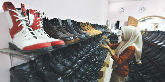 Seorang pembeli memilih sepatu produksi lokal di Desa Sengguruh, Kecamatan Kepanjen kemarin (1/5). Produksi sektor UMKM terus mengalami penurunan (Darmono/Radar Malang).