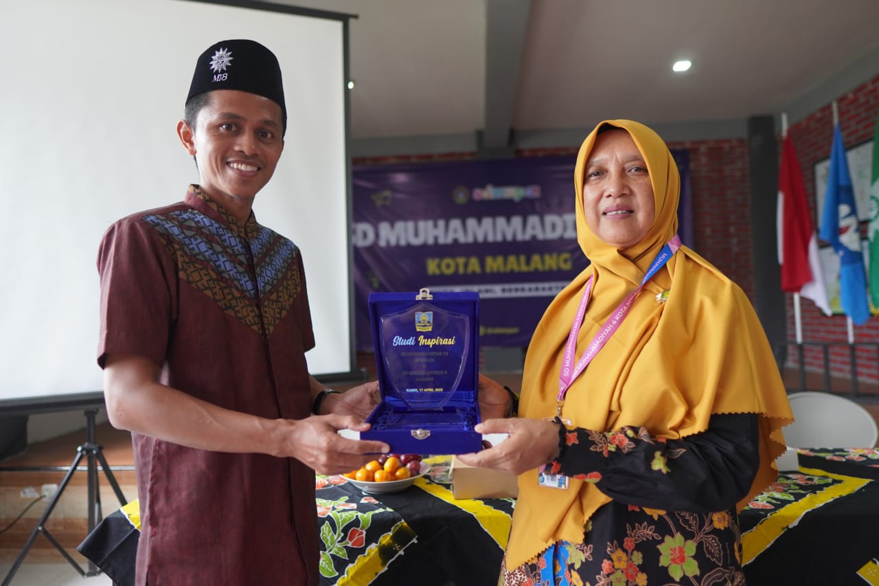 BERBAGI PENGALAMAN. Hana Ayudah menerima cenderamata dari kepala SD Muhammadiyah 18 Surabaya saat kunjungan lalu.